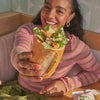 Woman holding Panera sandwich with lettuce, chicken, and cheese